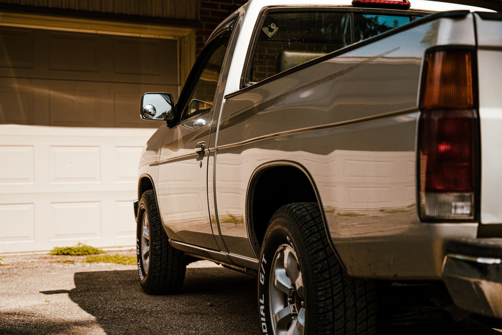 A pickup truck with a ladder rack parked in a residential driveway