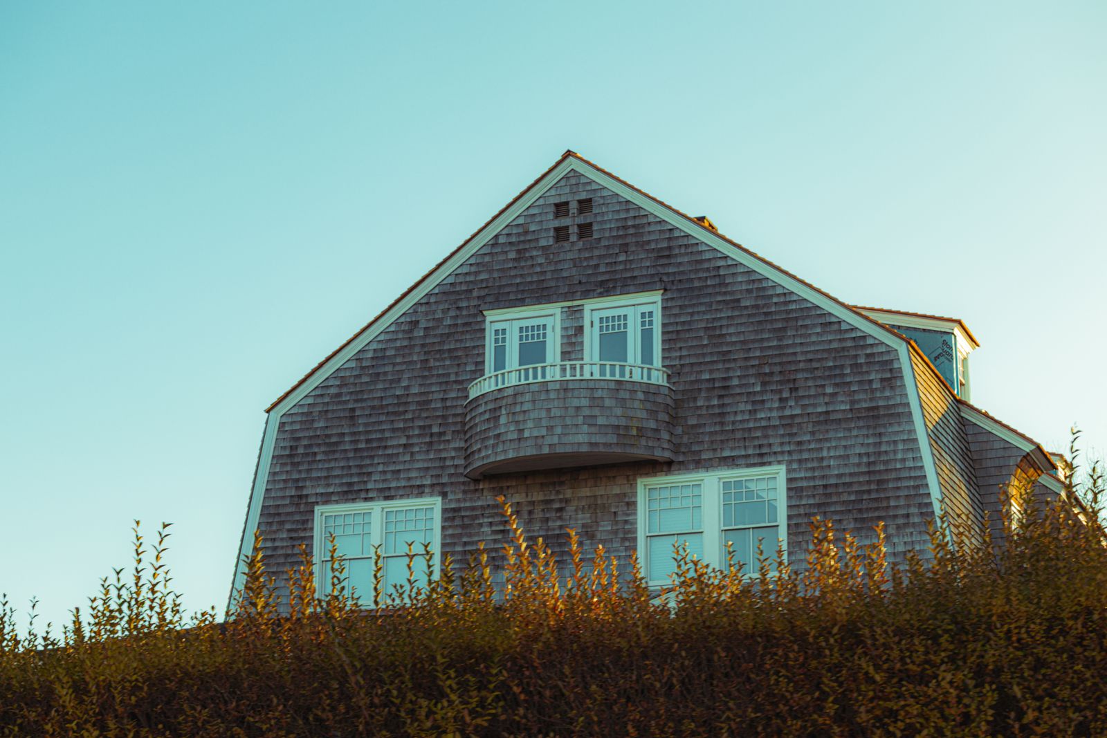 A two-storey New England house with a newly installed asphalt shingle roof